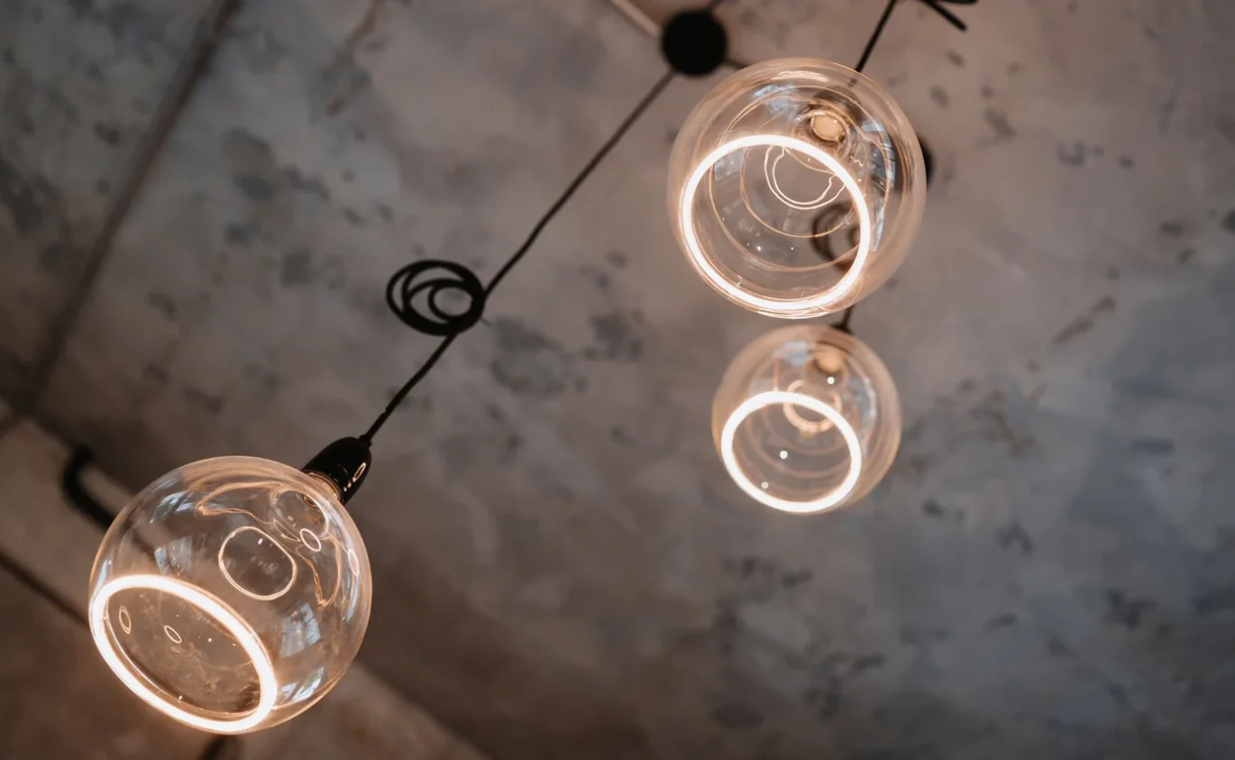 Segula Floating LED lichtbronnen in glazen bollen, hangend aan zwarte kabels onder een betonnen