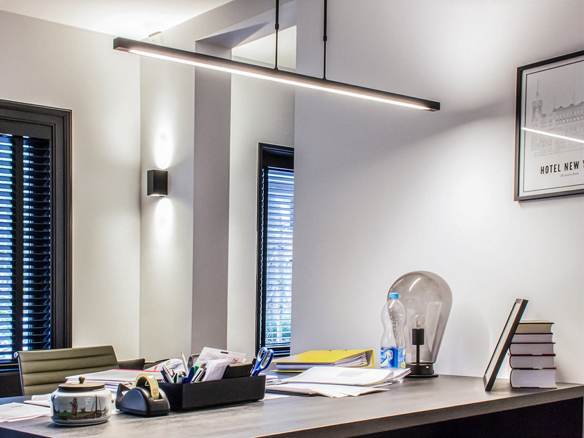 Moderne hanglamp boven een bureau in een strak ingericht kantoor – Straluma