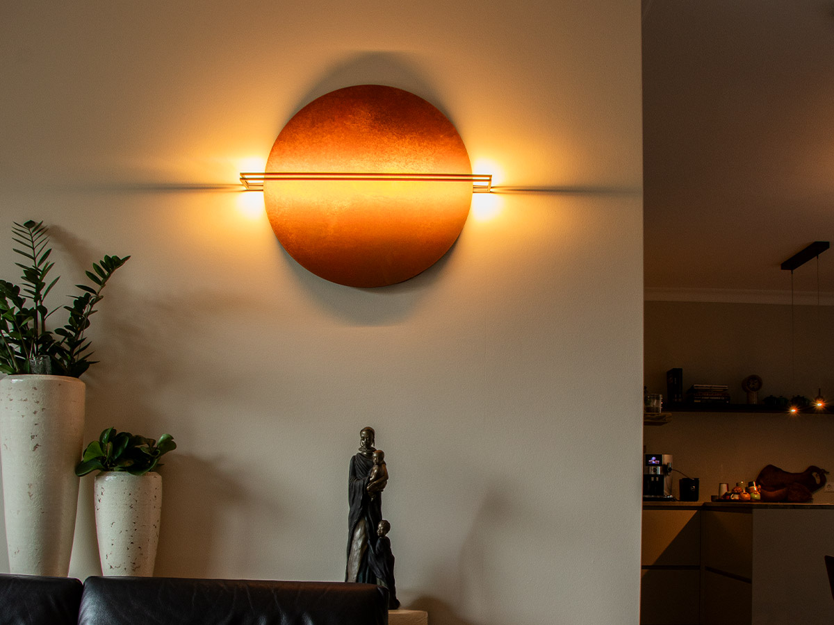 Ronde wandlamp met warme gloed in moderne woonkamer van een woning in Hendrik-Ido-Ambacht, geplaatst door Straluma.